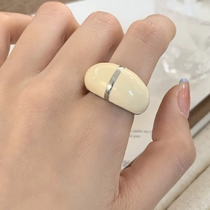 French vintage cream enamel ring with silver metal trim on finger for a stylish look