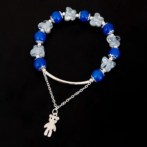 Vue détaillée du bracelet avec perles bleu foncé et pendentif ours en argent brillant