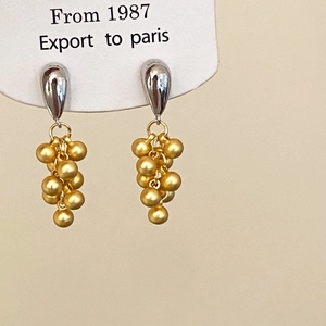 Detailed view of bicolor grape cluster earrings with silver waterdrop studs and gold beads