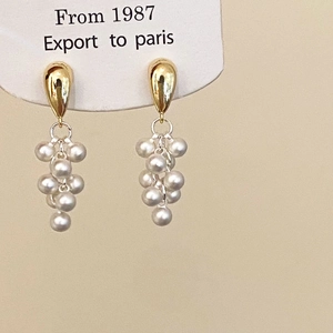 Detail of grape bunch pearl drop earrings with gold metallic stud and vintage French style