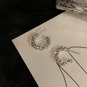 Detailed view of silver C-shaped earrings with textured finish and elegant metallic luster