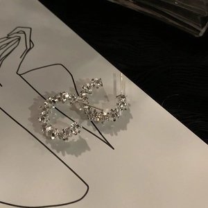 Detail of C-shaped silver earrings featuring unique textured crushed silver surface finish