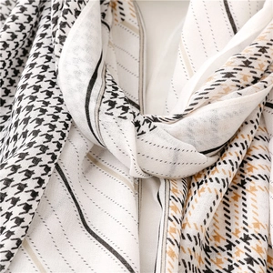 Detailopname van de houndstooth en gestreepte sjaaltextuur in zwart en kaki tinten