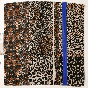 Macro shot of cotton linen scarf edge featuring leopard print and royal blue stripe detail