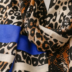 Close-up of leopard print cotton linen scarf with vibrant blue splicing and frayed edges