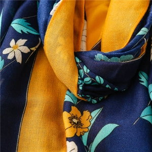 Detailaufnahme des Schals mit Blumenmuster, weicher Textur und leuchtend gelben Blüten