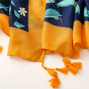 Nahaufnahme der floralen Schals mit gelben Quasten und marineblauen Gänseblümchenmustern