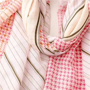 Detail van de lichte sjaalstof met kleurrijke houndstooth-print en streepjespatroon