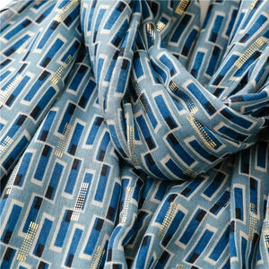Detailed macro shot of blue cotton-linen scarf with gold foil geometric patterns and texture