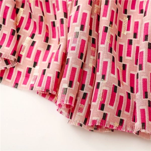 Detail of pink cotton-linen scarf featuring gold foil geometric patterns and frayed edges