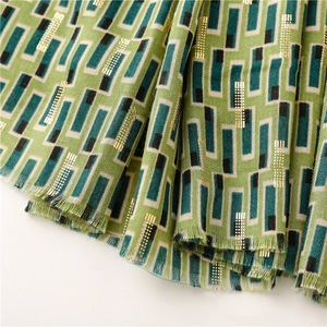 Close-up of geometric pattern cotton linen scarf with gold foil details and frayed edges