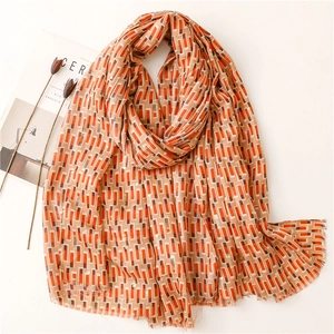 Detail of cotton linen scarf with orange geometric patterns and gold lurex threads