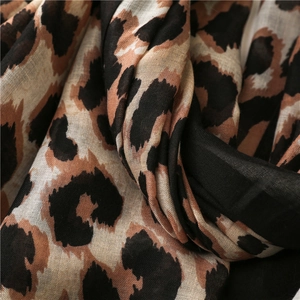 Macro view of leopard print cotton linen scarf showing lightweight breathable fabric texture