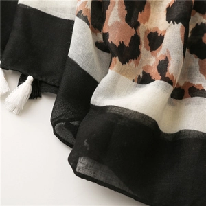 Close-up of leopard print cotton linen scarf with elegant fringe detail and soft texture
