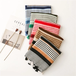 Detail view of cotton linen scarves with geometric grid patterns and handmade fringes