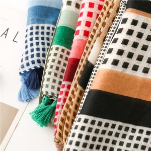 Close-up of geometric cotton scarves showing colorful patterns and handmade tassels