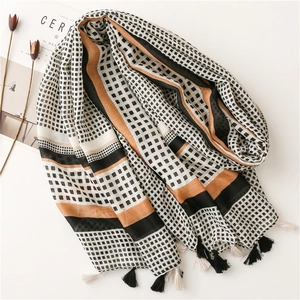 Close-up of lightweight cotton scarf with geometric patterns and handmade tassels
