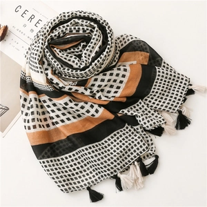 Detail of geometric cotton scarf showing texture with orange stripes and fringe trim