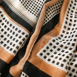 Detail of soft cotton-linen scarf showing geometric grid patterns and weave texture