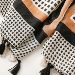 Detail of cotton linen scarf with geometric square patterns and handmade tassels