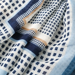 Close-up of soft satin cotton scarf featuring blue and khaki geometric check patterns