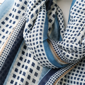 Detail of blue and white geometric pattern cotton scarf with fringe and soft texture