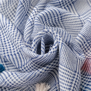 Detailaufnahme des blau-weiß karierten Baumwollschals mit weichen Fransen-Quasten