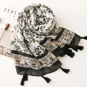 Close-up of floral pattern and black tassel detail on lightweight cotton linen scarf