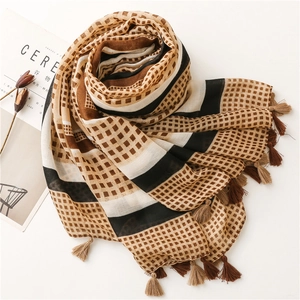 Detail view of woven cotton scarf featuring geometric blocks and handmade fringe edges