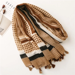 Detail shot of a cotton scarf with geometric patterns and handmade fringe edges