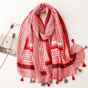 Detail view of red and white checkered cotton scarf with decorative fringe and tassels