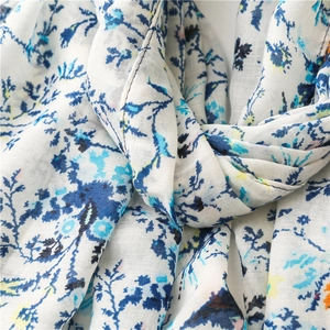 Detail of floral printed scarf showing delicate blue flower patterns and fine hem stitching