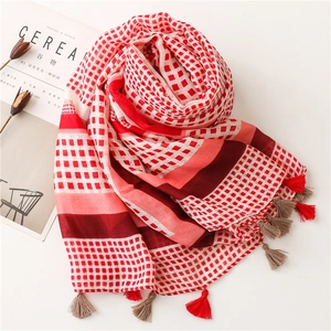 Detail of red and white checkered cotton scarf with multicolored handmade tassels
