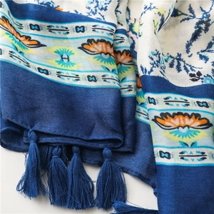 Close-up of soft floral cotton scarf featuring blue ethnic patterns and delicate fringe