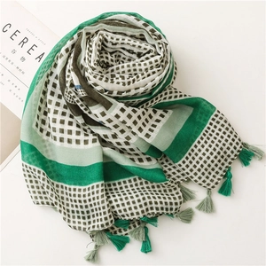 Detail of green geometric cotton scarf showing delicate fabric texture and dual-tone tassels