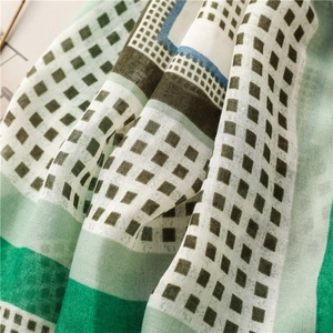 Detail of cotton linen scarf with geometric square print and soft woven fringe texture