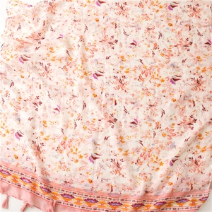 Detail of pink floral cotton scarf featuring ethnic patterns and soft fringe tassels
