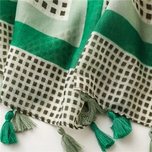 Macro detail of geometric pattern cotton scarf with woven tassel accents and textures
