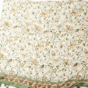 Detailed view of floral cotton scarf featuring delicate tassels and ethnic print patterns