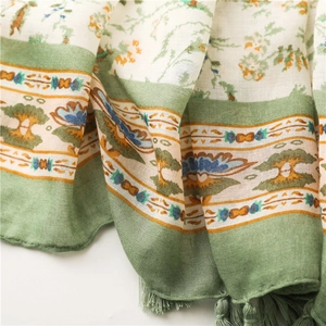 Detailed macro shot of a cotton linen scarf showing ethnic floral patterns and tassel trim