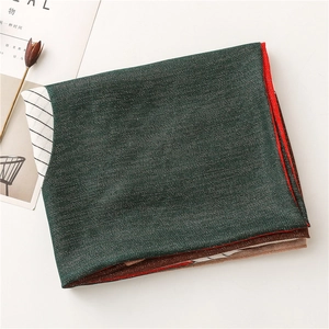 Detail of color-blocked cotton linen scarf featuring dark green, red and striped patterns