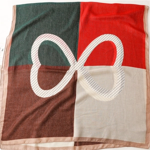 Close-up of four-color block linen scarf featuring a central infinity symbol and silky texture