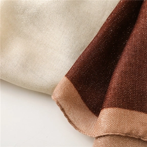 Detailed close-up of metallic lurex shawl with gold and reddish-brown shimmer texture