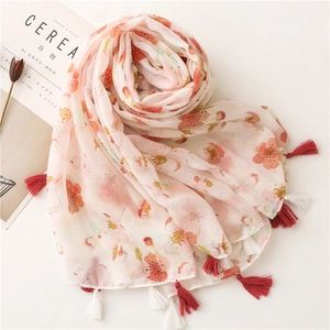 Detail showing sheer floral cotton linen scarf with soft pink flowers and fringe edges