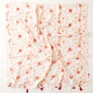Detail of soft cotton linen scarf with pink floral pattern and fringe tassels on fabric