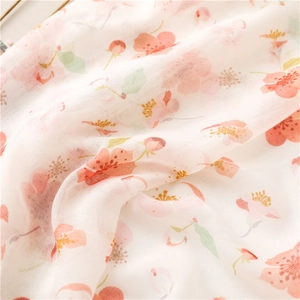 Close-up of lightweight cherry blossom cotton scarf with soft floral texture and fringes
