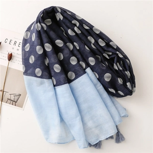 Detailed close-up of a blue two-tone scarf featuring polka dots and soft fringe tassels