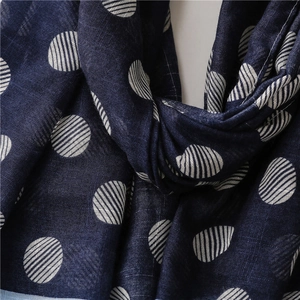 Detail of navy blue cotton linen scarf with white polka dots and woven texture