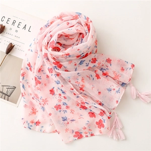 Detail of soft pink floral scarf with delicate fringe tassels and lightweight fabric