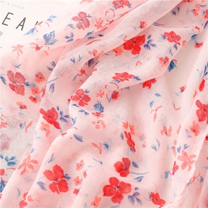 Detail of pink floral cotton-linen scarf fabric with delicate texture and fringe